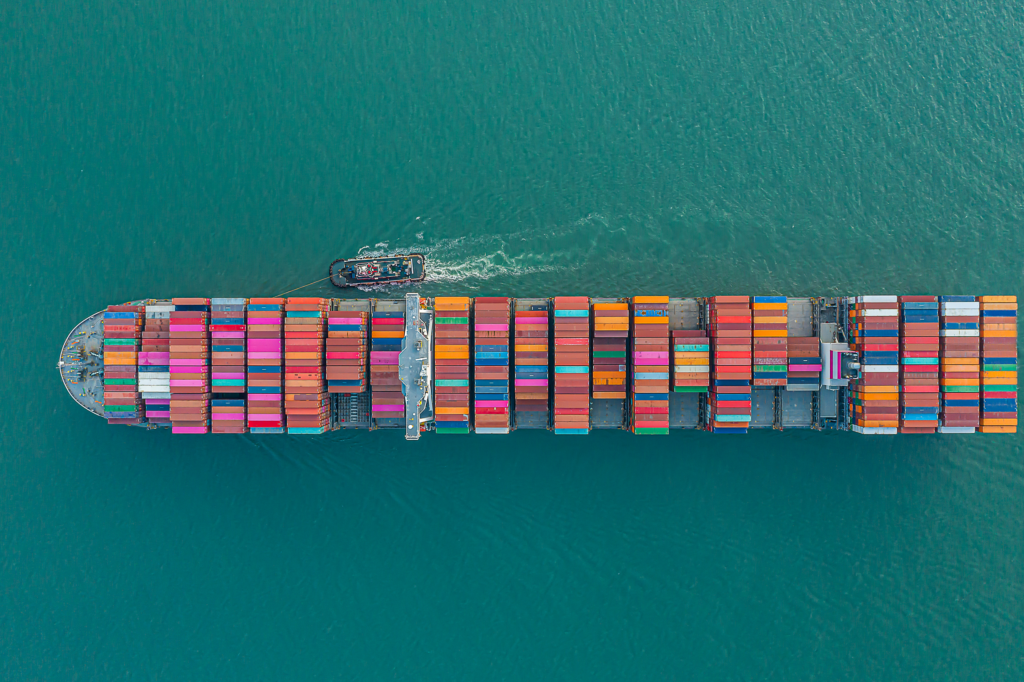 Large container ship loaded with cargo containers sailing on the ocean, representing international ocean freight services.